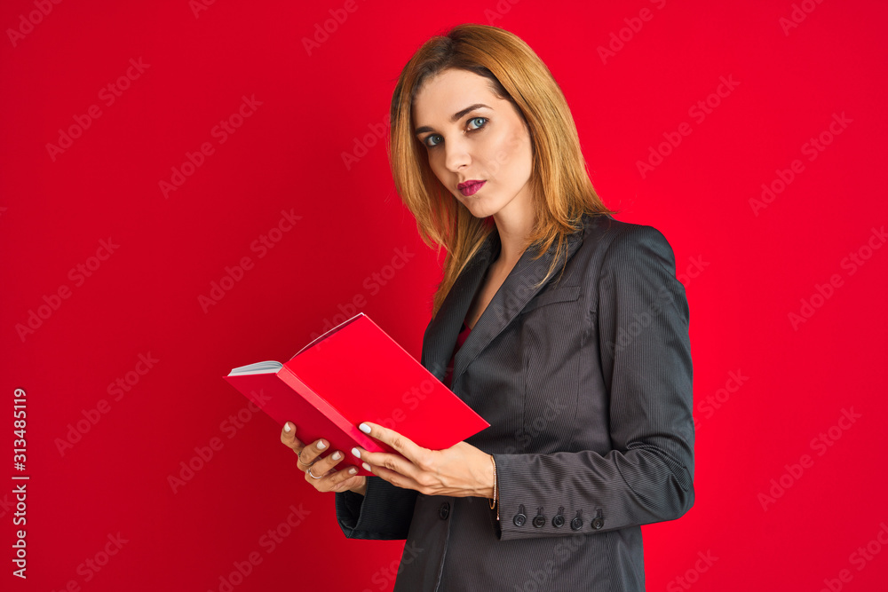 Young beautiful redhead businesswoman wearing suit reading book Young beautiful redhead businesswoman wearing suit reading book