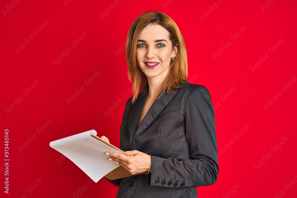 Young beautiful redhead businesswoman wearing suit writing on flip board Young beautiful redhead businesswoman wearing suit writing on flip board