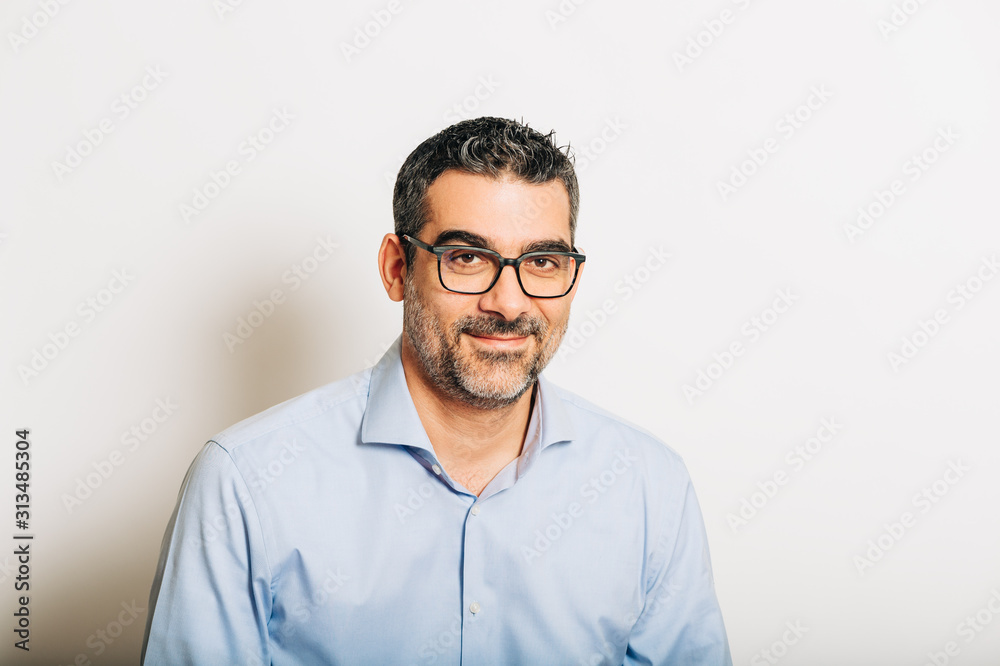 Studio portrait of handsome man wearing formal blue shirt and glasses, posing on white background Studio portrait of handsome man wearing formal blue shirt and glasses, posing on white background
