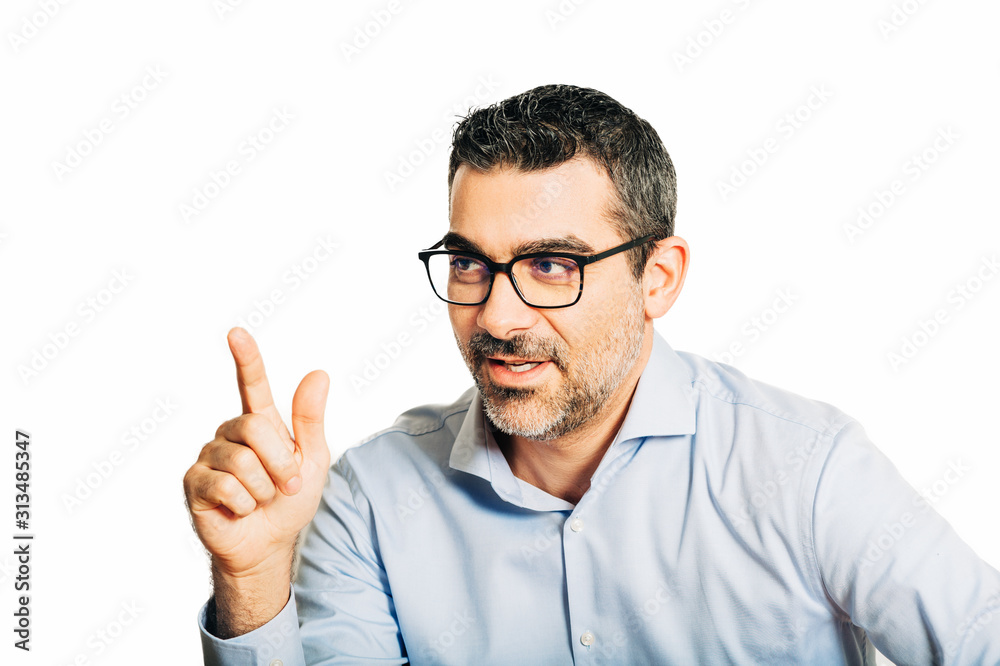 Studio portrait of handsome man wearing formal blue shirt and glasses, posing on white background, pointing finger up Studio portrait of handsome man wearing formal blue shirt and glasses, posing on white background, pointing finger up