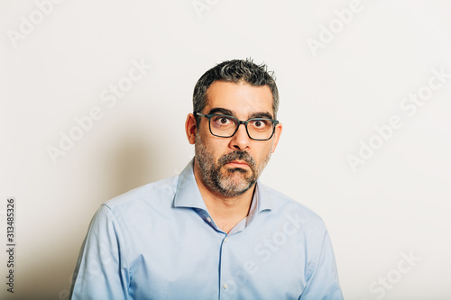 Studio portrait of surpresed man wearing glasses