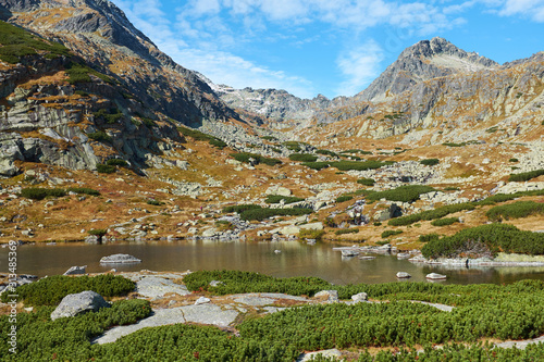 The beautiful lake Pleso nad Skokom in High Tatras National Park with peaks in the background, in Slovakia photo