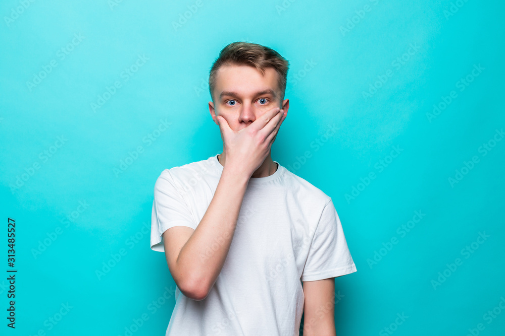 Portrait of amazed man covering his mouth over green background Portrait of amazed man covering his mouth over green background