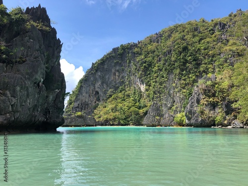 clear light blue ocean water on a tropical Asian island with limestone cliffs in the background. El Nido, Palawan, Philippines. © Magic Vova