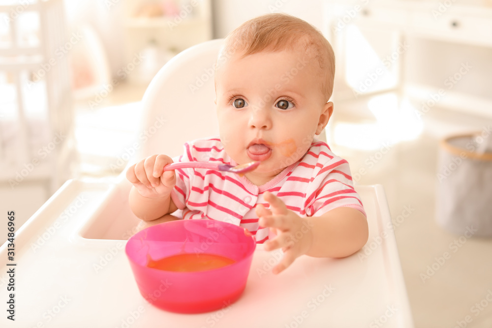 Portrait of cute little baby eating tasty food in kitchen Portrait of cute little baby eating tasty food in kitchen