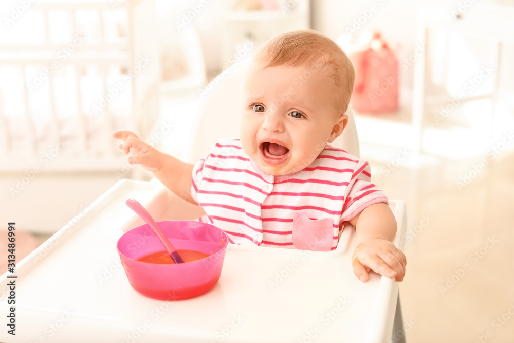Portrait of cute little baby eating tasty food in kitchen Portrait of cute little baby eating tasty food in kitchen