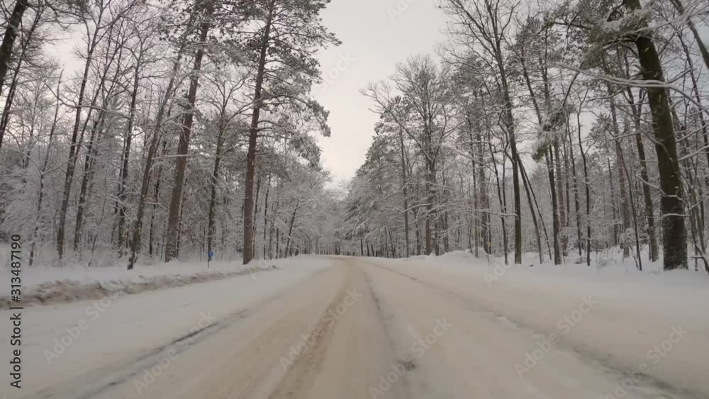 Hyperlapse POV of driving a car on asphalt road covered with snow and ice. Winter forest surrounded by trees with fresh snow Hyperlapse POV of driving a car on asphalt road covered with snow and ice. Winter forest surrounded by trees with fresh snow