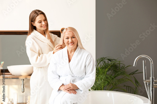 Adult daughter brushing hai...