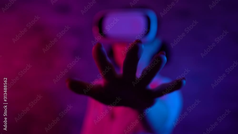Female gamer in virtual reality headset stretching out hand, simulation, closeup Female gamer in virtual reality headset stretching out hand, simulation, closeup
