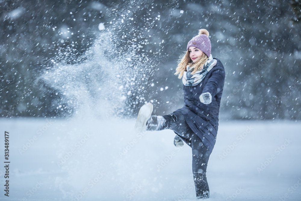 Young woman in warm clothes is having fun out of the snow Young woman in warm clothes is having fun out of the snow