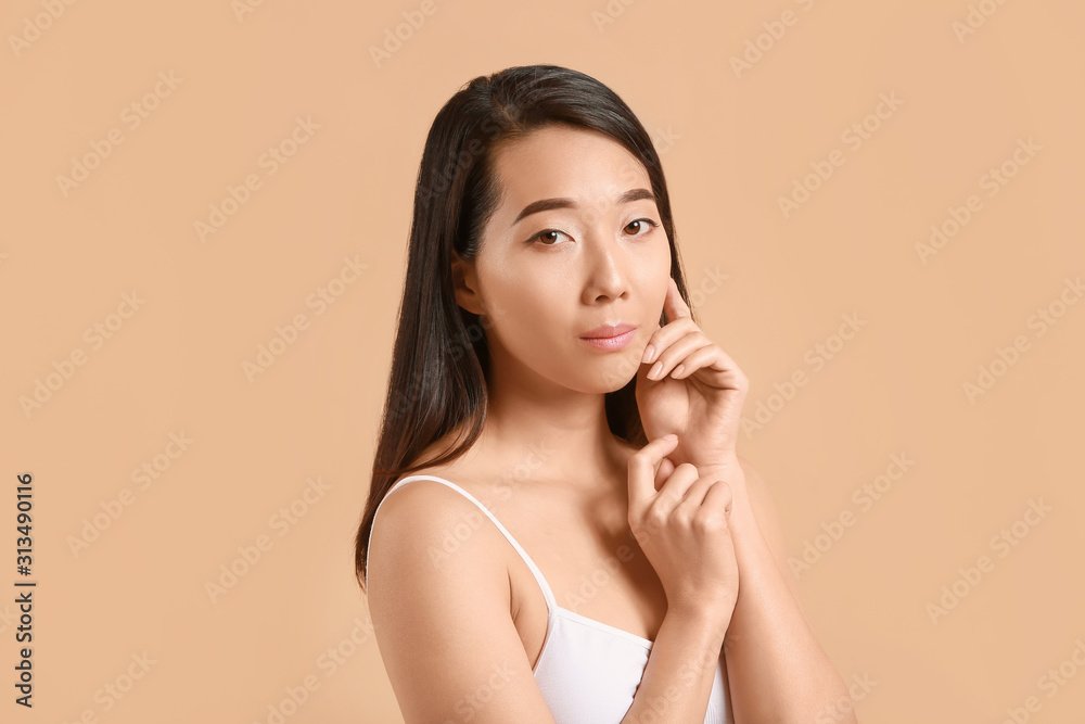 Beautiful young Asian woman with healthy skin on color background Beautiful young Asian woman with healthy skin on color background