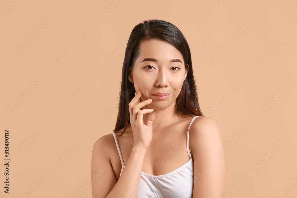 Beautiful young Asian woman with healthy skin on color background Beautiful young Asian woman with healthy skin on color background
