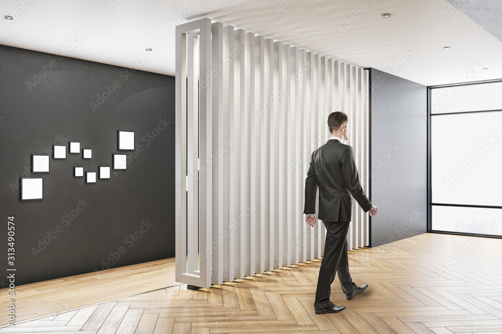 Businessman walking in contemporary office interior Businessman walking in contemporary office interior