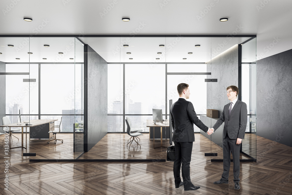 Two businessman shaking hands in modern office Two businessman shaking hands in modern office