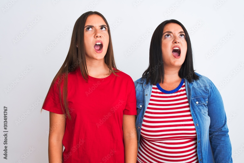 Young beautiful women wearing casual clothes standing over isolated white background angry and mad screaming frustrated and furious, shouting with anger. Rage and aggressive concept. Young beautiful women wearing casual clothes standing over isolated white background angry and mad screaming frustrated and furious, shouting with anger. Rage and aggressive concept.