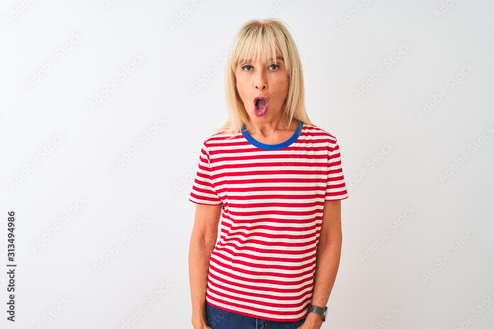 Middle age woman wearing casual striped t-shirt standing over isolated white background afraid and shocked with surprise expression, fear and excited face. Middle age woman wearing casual striped t-shirt standing over isolated white background afraid and shocked with surprise expression, fear and excited face.