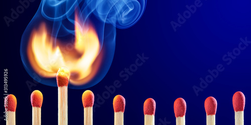 Row Of Matchsticks With One Bursting Into Flames - New Idea Concept photo