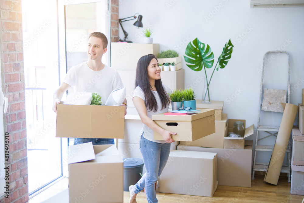 Young beautiful couple moving cardboard boxes at new home Young beautiful couple moving cardboard boxes at new home