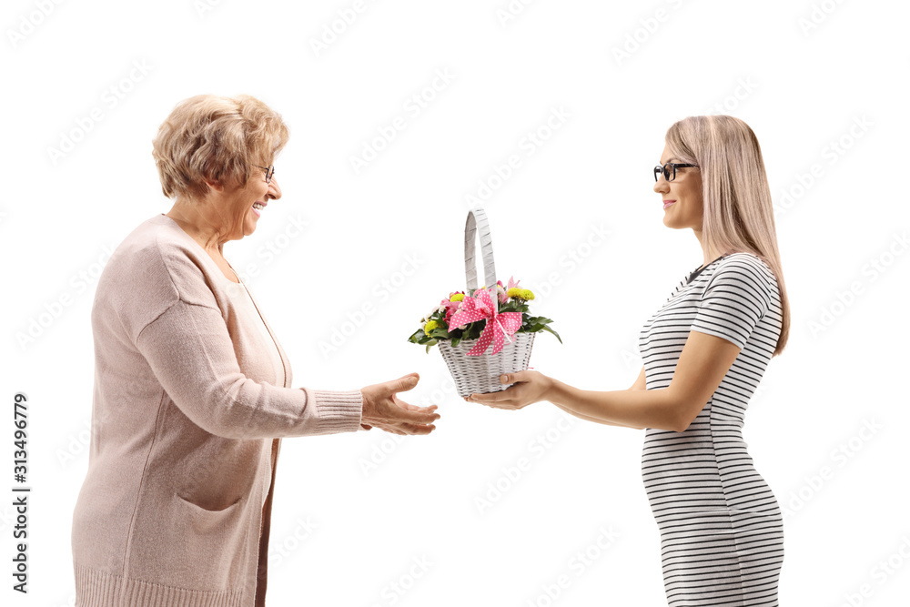 Young woman giving a basket with flowers to her mother