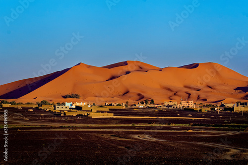 Desert landscape near Merzouga, small village in Morocco, known for its proximity to Erg Chebbi, tourists visiting Morocco, described as a desert theme park, and the Erg Chebbi as a wonderland of sand