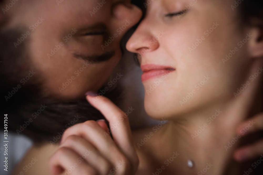 Defocused Top view of couple in love. Close-up portrait of the Lovers on the bed at home, head to head. The morning of the newlyweds, tenderly resting on festive day off at home. Concept of tactility Defocused Top view of couple in love. Close-up portrait of the Lovers on the bed at home, head to head. The morning of the newlyweds, tenderly resting on festive day off at home. Concept of tactility