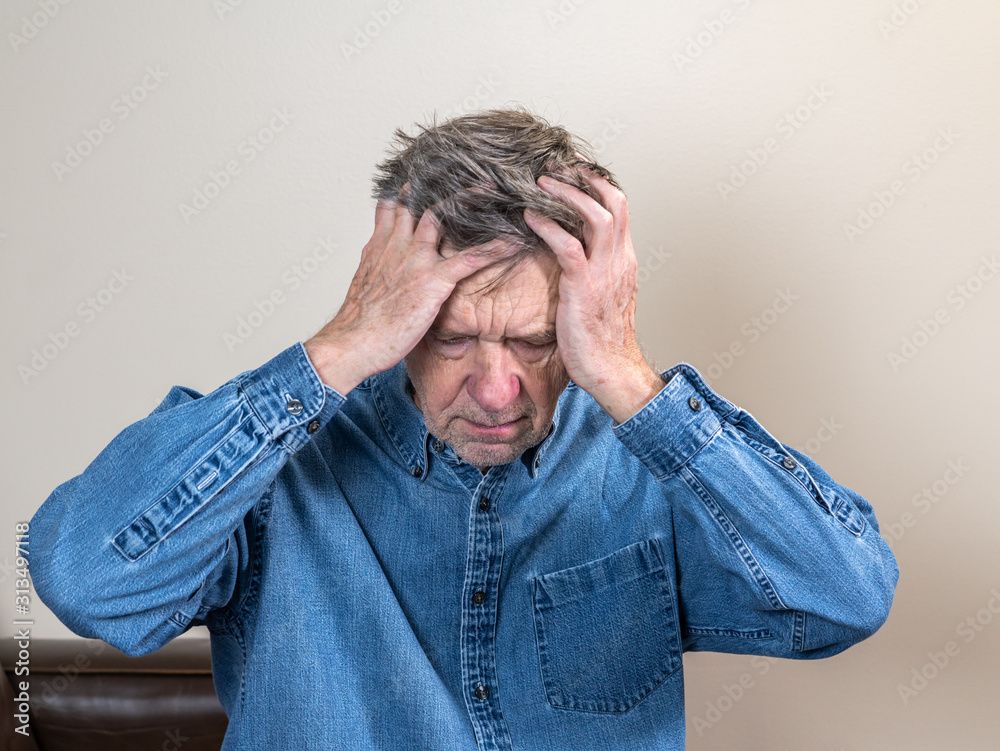 Head and shoulders portrait of a senior caucasian man with head in hands and looking depressed Head and shoulders portrait of a senior caucasian man with head in hands and looking depressed