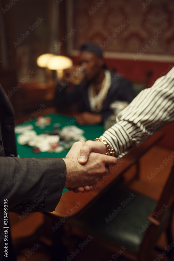 Obraz premium Male poker players shake hands in casino
