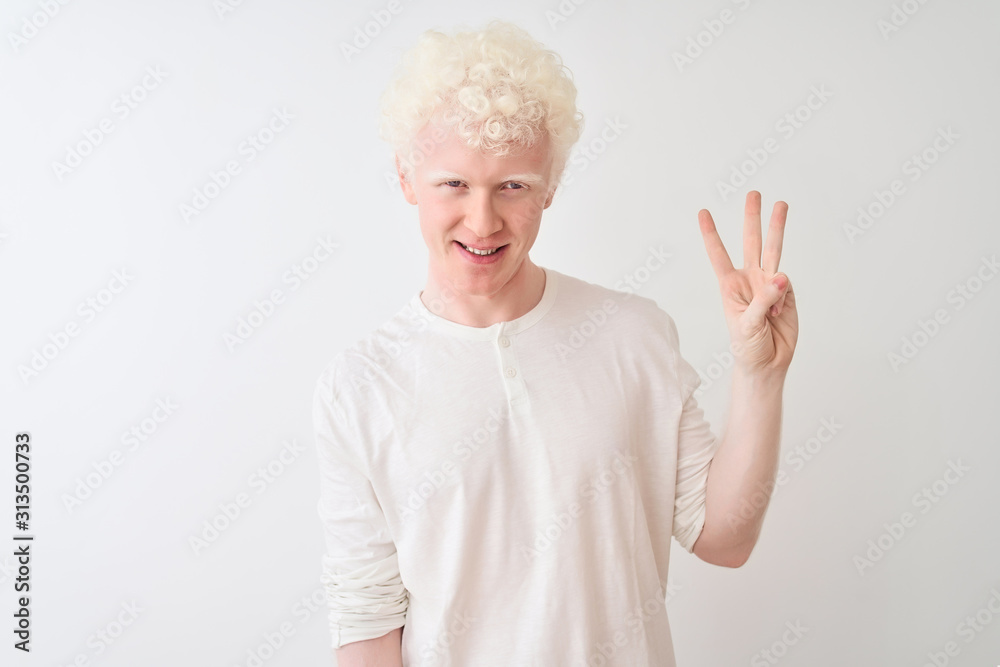 Young albino blond man wearing casual t-shirt standing over isolated white background showing and pointing up with fingers number three while smiling confident and happy. Young albino blond man wearing casual t-shirt standing over isolated white background showing and pointing up with fingers number three while smiling confident and happy.