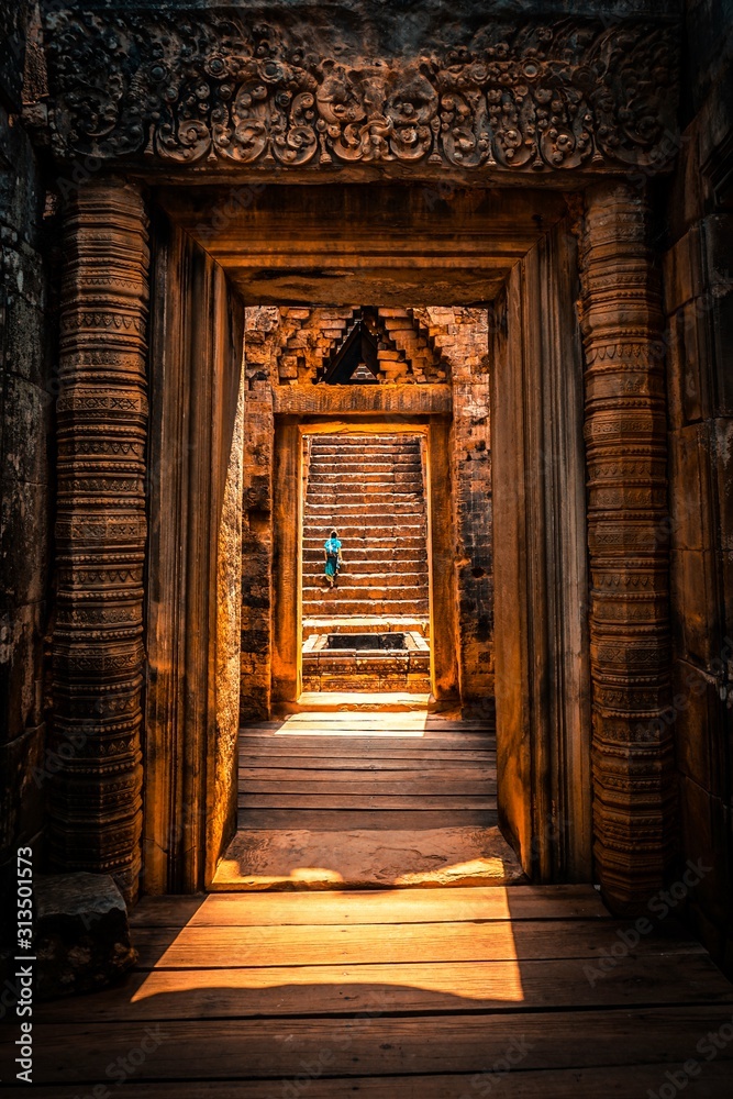 A woman climing the stairs of the ruins of temples in cambodia A woman climing the stairs of the ruins of temples in cambodia