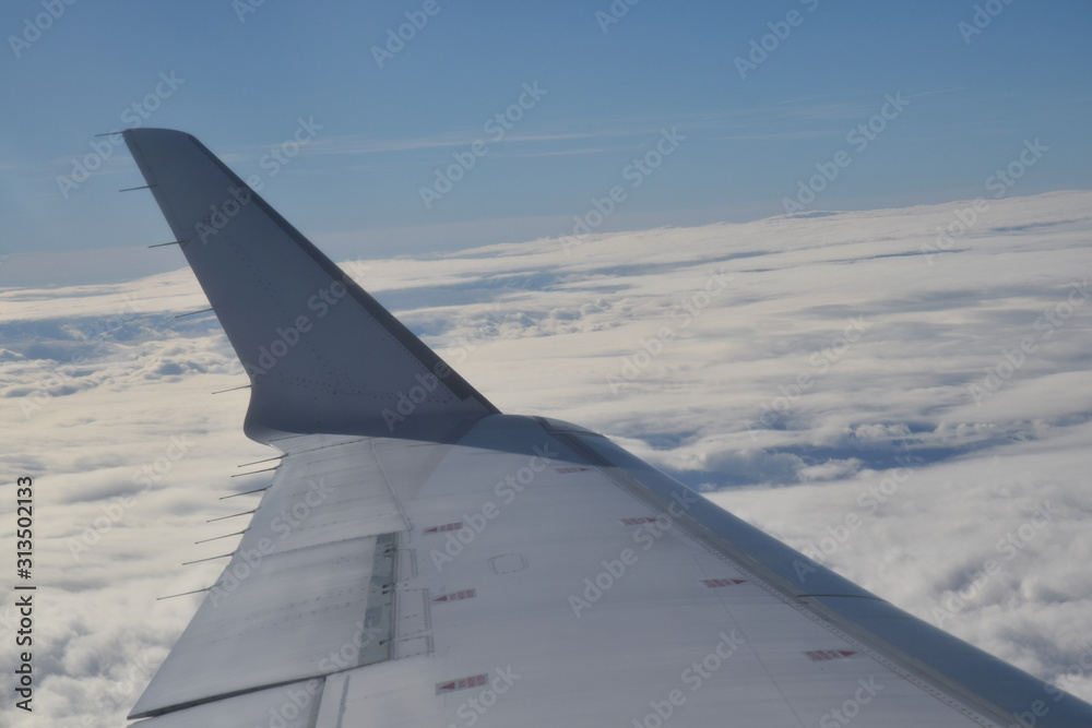 Nuages et aile d'avion vus en plein vol par le hublot