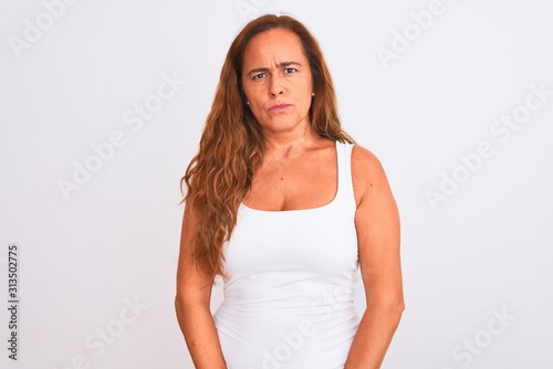 Middle age mature woman standing over white isolated background skeptic and nervous, frowning upset because of problem. Negative person.