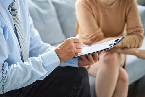 Young woman at a consultation with a psychotherapist. Psychologist having session with her patient in office, giving him advice about his life photo