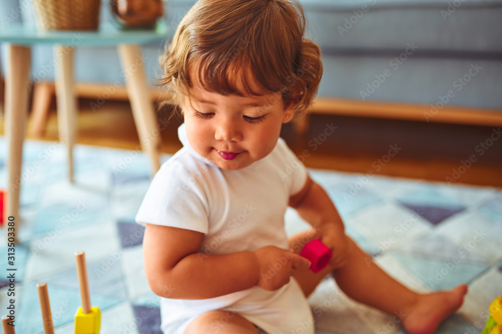 Beautiful toddler child girl playing with toys on the carpet Beautiful toddler child girl playing with toys on the carpet
