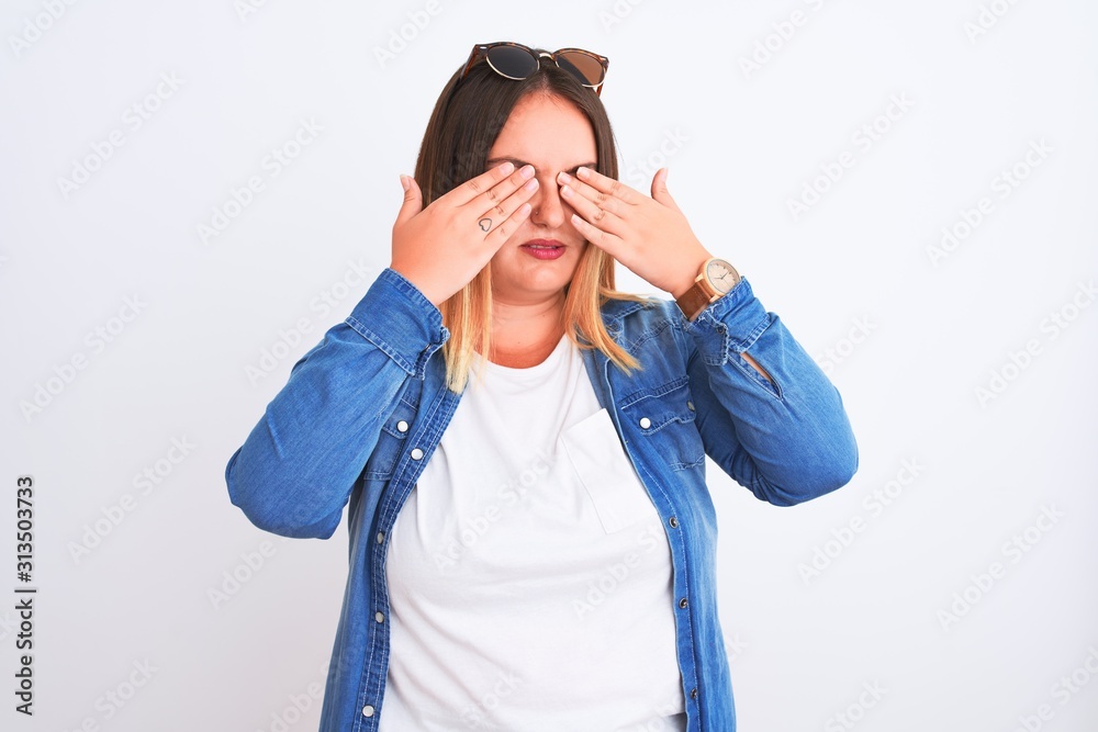 Beautiful woman wearing denim shirt standing over isolated white background rubbing eyes for fatigue and headache, sleepy and tired expression. Vision problem Beautiful woman wearing denim shirt standing over isolated white background rubbing eyes for fatigue and headache, sleepy and tired expression. Vision problem