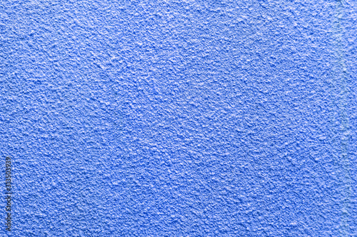 Bright classic blue textured uneven wall. Close-up. Abstract background and texture for design.
