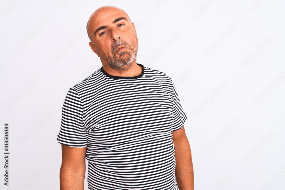 Middle age handsome man wearing striped navy t-shirt over isolated white background looking sleepy and tired, exhausted for fatigue and hangover, lazy eyes in the morning. Middle age handsome man wearing striped navy t-shirt over isolated white background looking sleepy and tired, exhausted for fatigue and hangover, lazy eyes in the morning.