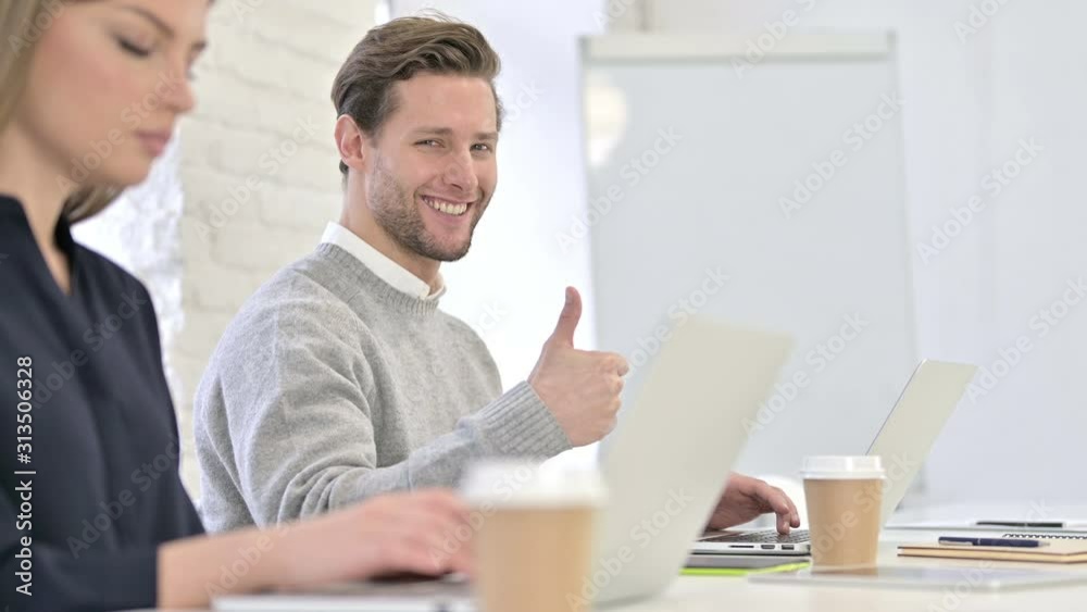 Ambitious Creative Man showing Thumbs Up in Office Ambitious Creative Man showing Thumbs Up in Office