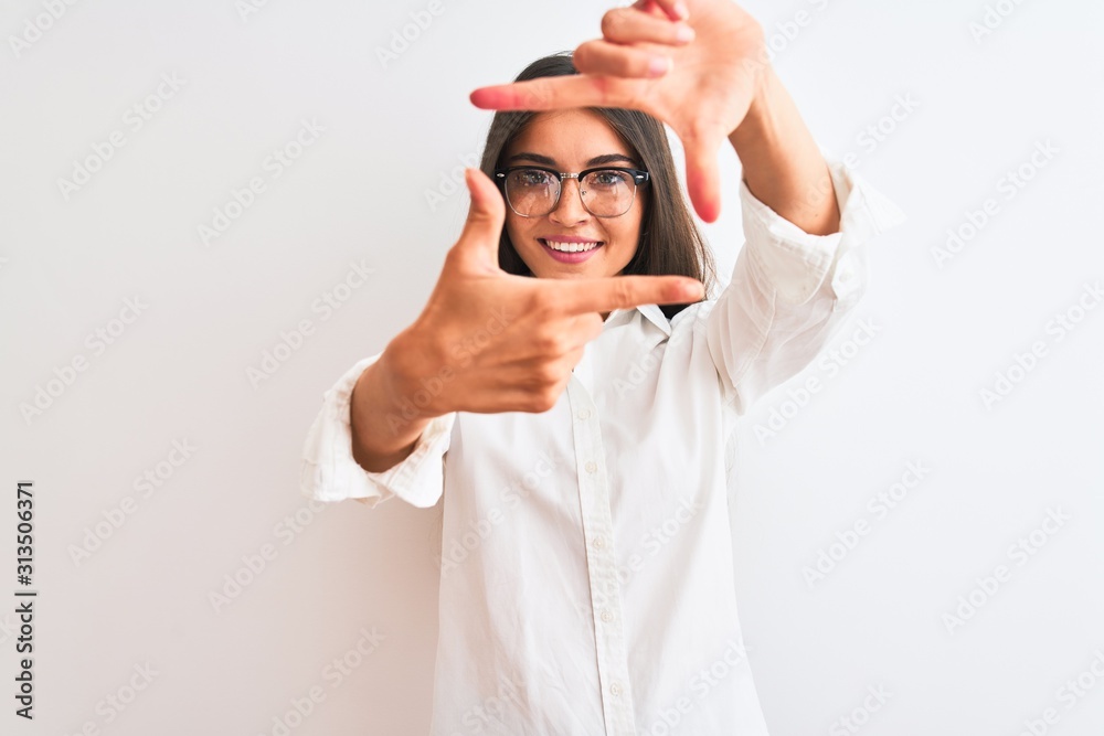 Young beautiful businesswoman wearing glasses standing over isolated white background smiling making frame with hands and fingers with happy face. Creativity and photography concept. Young beautiful businesswoman wearing glasses standing over isolated white background smiling making frame with hands and fingers with happy face. Creativity and photography concept.