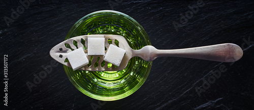 absinthe with sugar cubes and spoon flat lay composition photo