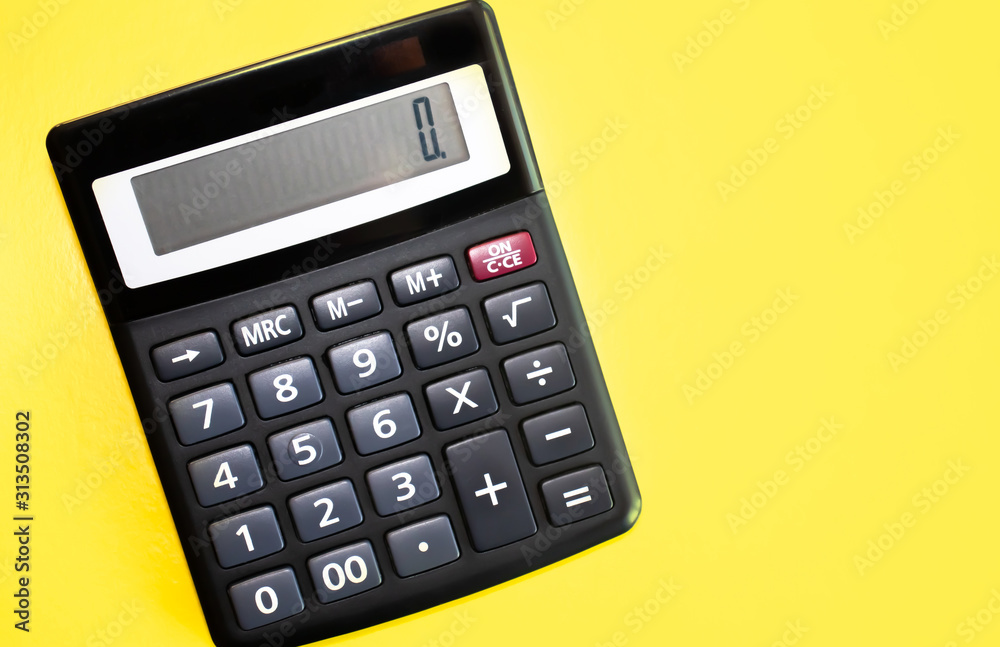 Flat lay or top view of black pen with calculator on vivid yellow background table with blank copy space, math, cost, tax or investment calculation. Flat lay or top view of black pen with calculator on vivid yellow background table with blank copy space, math, cost, tax or investment calculation.
