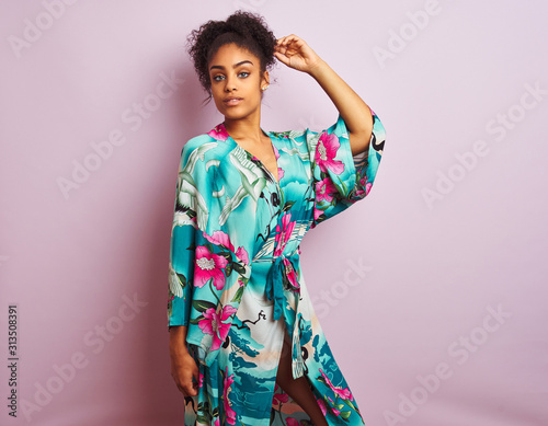 Young beautiful african american woman standing wearing elegant colorful caftan