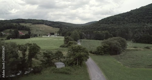Aerial drone flight over a country road in cloudy weather