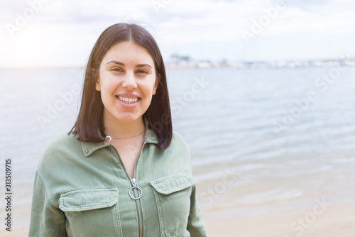Young beautiful woman smiling very happy by the beach