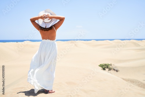 Young beautiful woman smiling happy enjoying summer vacation at maspalomas dunes beach photo
