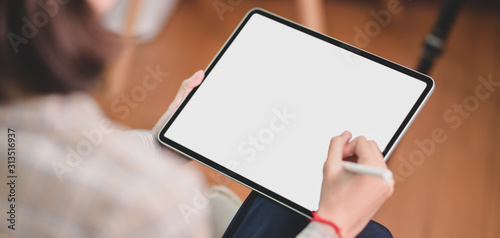 Cropped shot of businesswoman working on her project while using blank screen digital tablet