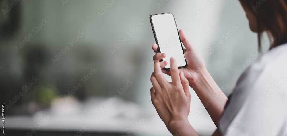Close-up view of professional doctor using blank screen smartphone in her office room - obrazy, fototapety, plakaty 