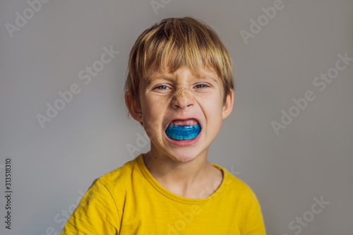 Six-year old boy shows myofunctional trainer. Helps equalize the growing teeth and correct bite, develop mouth breathing habit. Corrects the position of the tongue photo