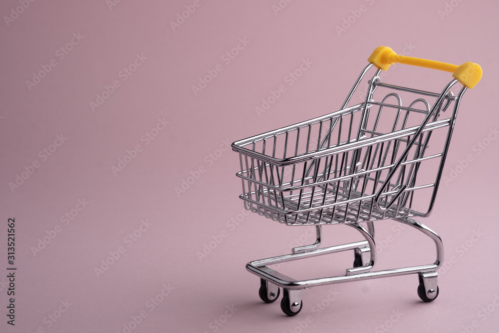 Turned pushcart empty on pale pink background, Black Friday concept.