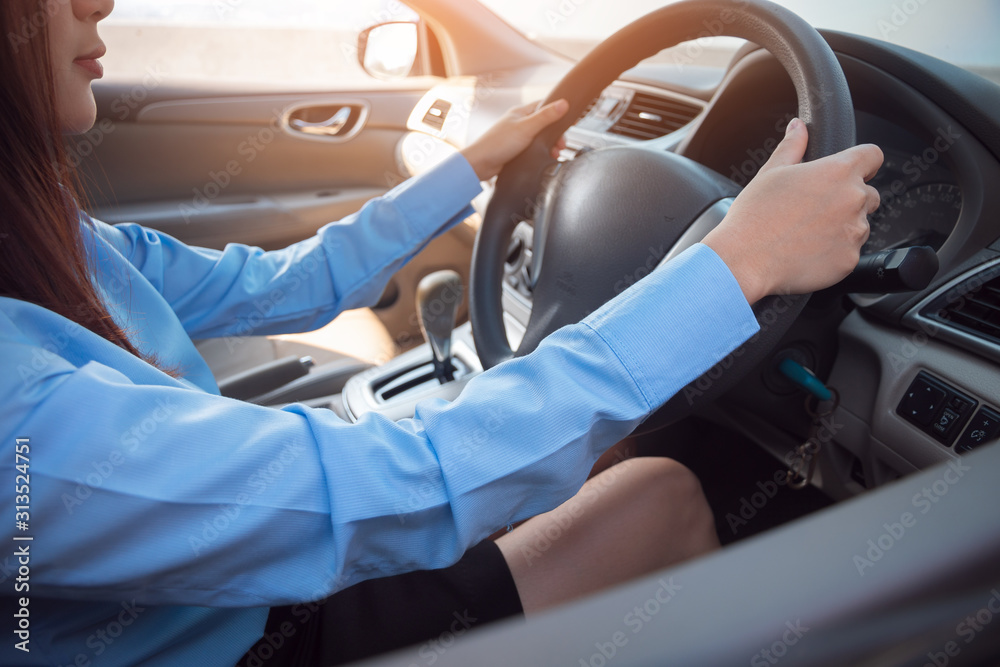 Business woman driving her car, hands holding steering wheel.
