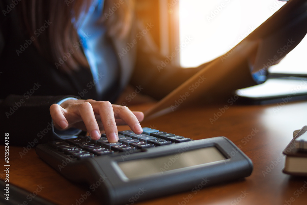 Business woman hand pressing on calculator for calculating cost estimating. Business woman hand pressing on calculator for calculating cost estimating.